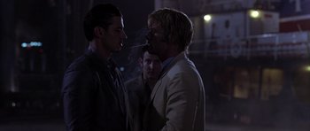 Movie still from “The Punisher” (2004), directed by Jonathan Hensleigh – Two men smoking a cigarette while another man looks on; Medium shot, Over the shoulder angle