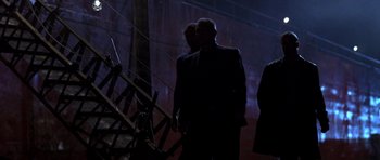Movie still from “The Punisher” (2004), directed by Jonathan Hensleigh – A man in a black suit standing in a dark room; Wide shot, Low angle