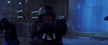 Movie still from “The Punisher” (2004), directed by Jonathan Hensleigh – A man in a black uniform holding a gun; Medium shot, Low angle