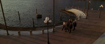 Movie still from “The Punisher” (2004), directed by Jonathan Hensleigh – A group of people walking along a pier near a body of water; Extreme Wide shot, High angle