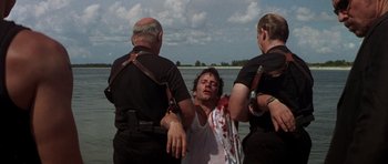 Movie still from “The Punisher” (2004), directed by Jonathan Hensleigh – A man is being held up by two police officers; Medium shot, Over the shoulder angle
