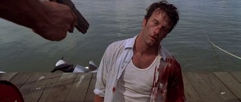 Movie still from “The Punisher” (2004), directed by Jonathan Hensleigh – A man with a gun and blood on his face; Medium shot, Low angle