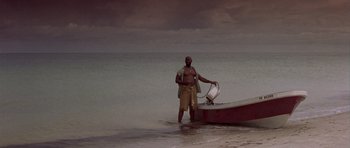 Movie still from “The Punisher” (2004), directed by Jonathan Hensleigh – A man standing next to a boat in the ocean; Wide shot, Low angle