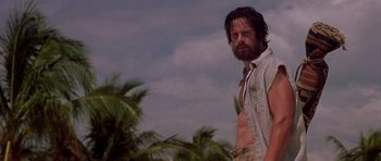Movie still from “The Punisher” (2004), directed by Jonathan Hensleigh – A man standing in front of some palm trees; Medium shot, Low angle