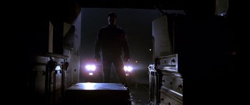 Movie still from “The Punisher” (2004), directed by Jonathan Hensleigh – A man standing next to a truck at night with headlights on; Wide shot, Low angle