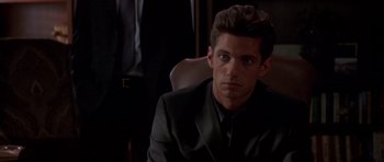 Movie still from “The Punisher” (2004), directed by Jonathan Hensleigh – A man in a suit sitting in a chair looking at the camera; Close Up shot, Over the shoulder angle