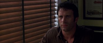 Movie still from “The Punisher” (2004), directed by Jonathan Hensleigh – A person wearing a brown shirt near a window; Close Up shot, Over the shoulder angle