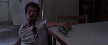 Movie still from “The Punisher” (2004), directed by Jonathan Hensleigh – A man with blood on his face holding a toy gun; Medium shot, Low angle