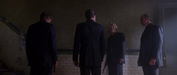 Movie still from “The Punisher” (2004), directed by Jonathan Hensleigh – A group of people standing next to each other in a room; Wide shot, Low angle