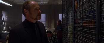 Movie still from “The Punisher” (2004), directed by Jonathan Hensleigh – A man standing in front of a metal cage; Medium shot, Over the shoulder angle