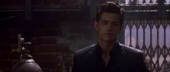 Movie still from “The Punisher” (2004), directed by Jonathan Hensleigh – A man in a black suit standing next to a brick wall; Close Up shot, Over the shoulder angle