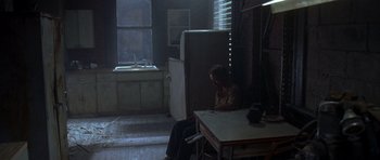 Movie still from “The Punisher” (2004), directed by Jonathan Hensleigh – A person sitting at a table in a dark room; Wide shot, High angle