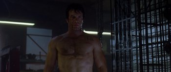 Movie still from “The Punisher” (2004), directed by Jonathan Hensleigh – A shirtless man standing in a dark room; Medium shot, Low angle