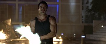 Movie still from “The Punisher” (2004), directed by Jonathan Hensleigh – A man with his arms crossed standing in front of a fire; Medium shot, Low angle