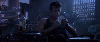 Movie still from “The Punisher” (2004), directed by Jonathan Hensleigh – A man sitting in a chair holding a piece of paper; Close Up shot, Low angle