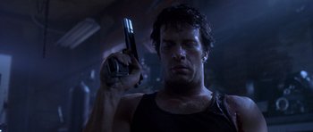 Movie still from “The Punisher” (2004), directed by Jonathan Hensleigh – A man holding a gun in a dark room; Close Up shot, Low angle