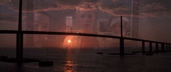 Movie still from “The Punisher” (2004), directed by Jonathan Hensleigh – A picture of a bridge and a woman in front of a sunset; Extreme Wide shot, Low angle