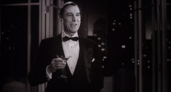 Movie still from “The Purple Rose of Cairo” (1985), directed by Woody Allen – A man in a tuxedo holding a glass of wine; Medium shot, Low angle