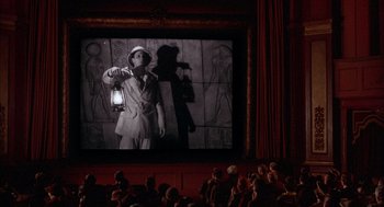 Movie still from “The Purple Rose of Cairo” (1985), directed by Woody Allen – People watching a movie in a large auditorium; Wide shot, High angle