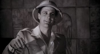 Movie still from “The Purple Rose of Cairo” (1985), directed by Woody Allen – A black and white photo of a man wearing a hat; Close Up shot, Low angle