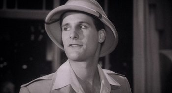 Movie still from “The Purple Rose of Cairo” (1985), directed by Woody Allen – A black and white photo of a man wearing a hat; Close Up shot, Low angle