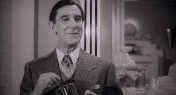 Movie still from “The Purple Rose of Cairo” (1985), directed by Woody Allen – An older man wearing a suit and tie holding a glass; Close Up shot, Low angle
