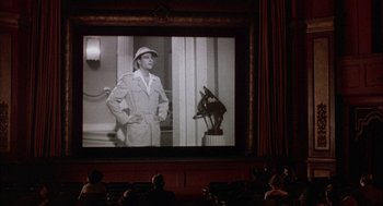 Movie still from “The Purple Rose of Cairo” (1985), directed by Woody Allen – People sitting in front of a large screen in a movie theater; Wide shot, Low angle