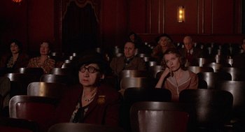 Movie still from “The Purple Rose of Cairo” (1985), directed by Woody Allen – A group of people sitting in a movie theater; Wide shot, High angle