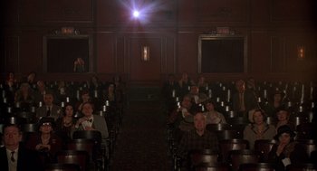 Movie still from “The Purple Rose of Cairo” (1985), directed by Woody Allen – A group of people sitting in rows in an auditorium; Wide shot, High angle