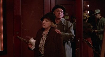 Movie still from “The Purple Rose of Cairo” (1985), directed by Woody Allen – An older woman and a younger man standing next to each other; Medium shot, Low angle