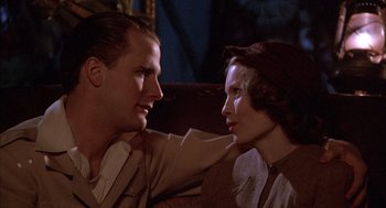 Movie still from “The Purple Rose of Cairo” (1985), directed by Woody Allen – A man and a woman sitting next to each other on a couch; Close Up shot, Low angle