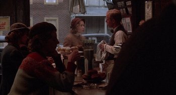 Movie still from “The Purple Rose of Cairo” (1985), directed by Woody Allen – A group of people sitting around a table; Medium shot, Over the shoulder angle