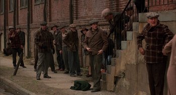 Movie still from “The Purple Rose of Cairo” (1985), directed by Woody Allen – A group of men standing next to each other on a sidewalk; Wide shot, High angle