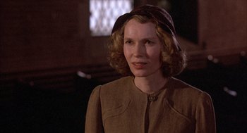 Movie still from “The Purple Rose of Cairo” (1985), directed by Woody Allen – A woman in a brown coat and a hat; Close Up shot, Over the shoulder angle