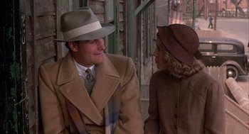 Movie still from “The Purple Rose of Cairo” (1985), directed by Woody Allen – A man and a woman wearing coats and hats; Medium shot, Over the shoulder angle