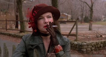 Movie still from “The Purple Rose of Cairo” (1985), directed by Woody Allen – A woman in a hat and gloves smoking a cigarette; Close Up shot, Over the shoulder angle