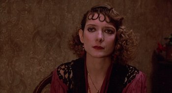 Movie still from “The Purple Rose of Cairo” (1985), directed by Woody Allen – A person with curly hair wearing a dress; Close Up shot, Over the shoulder angle