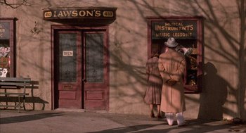 Movie still from “The Purple Rose of Cairo” (1985), directed by Woody Allen – Two people standing outside of a musical instrument store; Wide shot, High angle