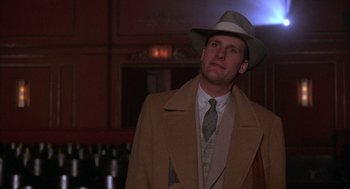 Movie still from “The Purple Rose of Cairo” (1985), directed by Woody Allen – A man wearing a hat and a coat; Close Up shot, Low angle