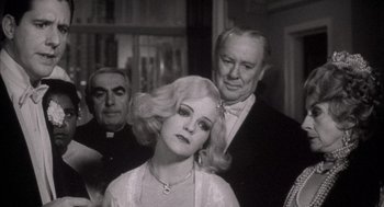 Movie still from “The Purple Rose of Cairo” (1985), directed by Woody Allen – An old photo of a man and a woman with a priest; Close Up shot, Low angle