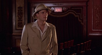 Movie still from “The Purple Rose of Cairo” (1985), directed by Woody Allen – A man wearing a hat and a suit in a theater; Medium shot, Over the shoulder angle