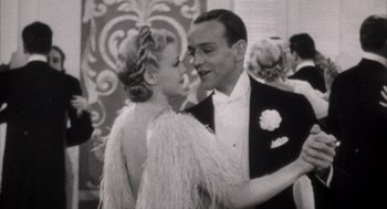 Movie still from “The Purple Rose of Cairo” (1985), directed by Woody Allen – A man and a woman are dancing together in formal wear; Medium shot, Low angle