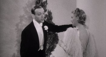 Movie still from “The Purple Rose of Cairo” (1985), directed by Woody Allen – A man and a woman in formal attire; Medium shot, Low angle