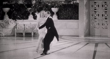 Movie still from “The Purple Rose of Cairo” (1985), directed by Woody Allen – A man and a woman are dancing in a ballroom; Wide shot, High angle
