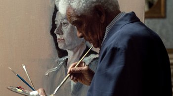 Movie still from “The Queen” (2006), directed by Stephen Frears – An older man painting a portrait of a woman with paintbrushes; Close Up shot, Low angle