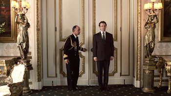 Movie still from “The Queen” (2006), directed by Stephen Frears – Two men standing in front of a door; Wide shot, Low angle