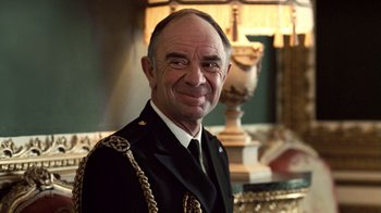 Movie still from “The Queen” (2006), directed by Stephen Frears – A person wearing a suit and tie; Close Up shot, Low angle