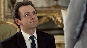 Movie still from “The Queen” (2006), directed by Stephen Frears – A man in a suit and tie looking up at something; Close Up shot, High angle