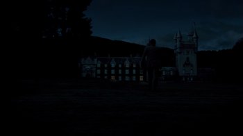 Movie still from “The Queen” (2006), directed by Stephen Frears – A person standing in a field at night with a castle in the background; Extreme Wide shot, Low angle