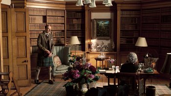 Movie still from “The Queen” (2006), directed by Stephen Frears – A man and a woman are in a library; Wide shot, High angle